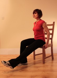 Sitting forwards with long leg lifted just off the floor