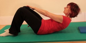 Reaching hand to oppostie knee for obliques strengthener